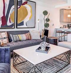 a living room with a kitchen in the background