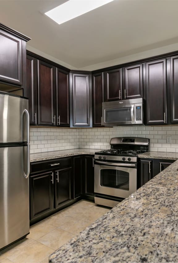 a kitchen with stainless steel appliances and granite counter tops at The Collings at the Lumberyard, Collingswood, 08108