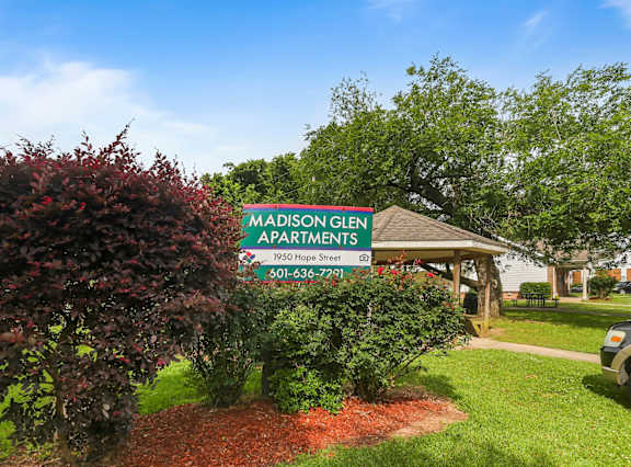 A family of four hugging outside a house.