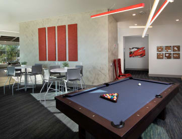 a game room with a pool table and chairs