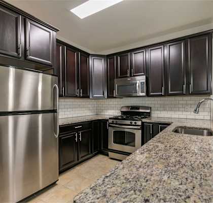 a kitchen with stainless steel appliances and granite counter tops at The Collings at the Lumberyard, Collingswood, 08108