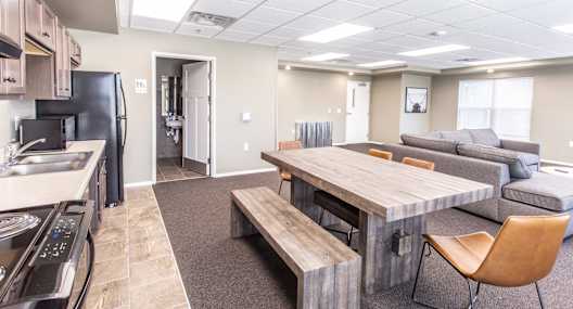 a kitchen and living room with a wooden dining table