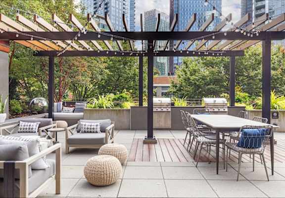 A patio with a table and chairs under a pergola.