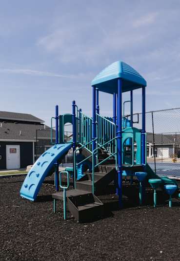 A playground with a blue slide and tower.