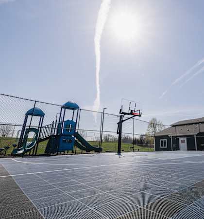 A basketball court with a blue slide in the background.