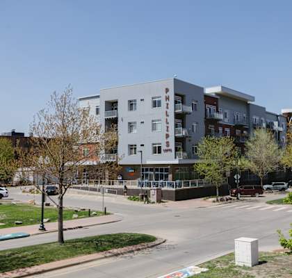 A modern apartment building with a parking lot in front.