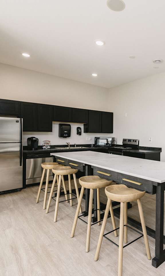 A modern kitchen with a large island and stools.