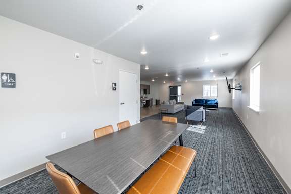 A conference room with a long table and chairs.