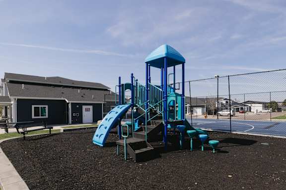 A playground with a blue slide and tower.