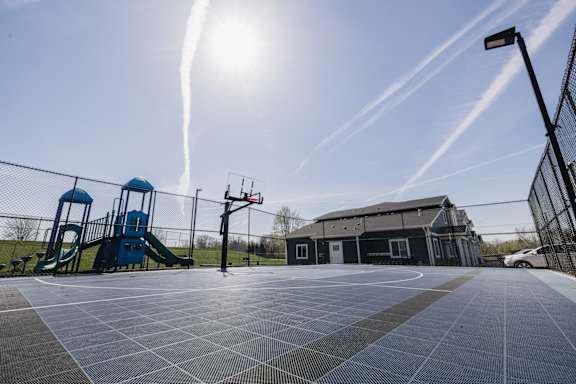 A basketball court with a blue slide in the background.