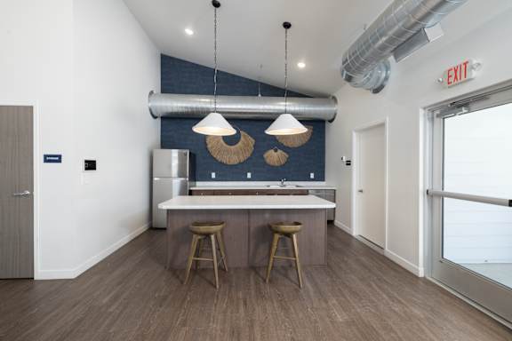 A kitchen with a bar and two stools.