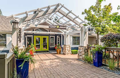 the front entrance of a home with a patio and a green door