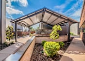 Thumbnail 6 of 30 - Covered outdoor lounge with grills and bar seating