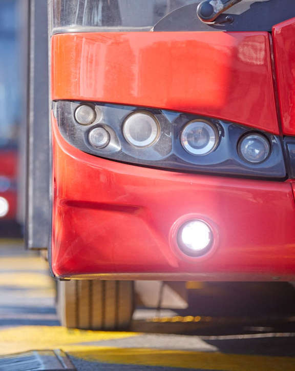 a close up of the front of a red bus