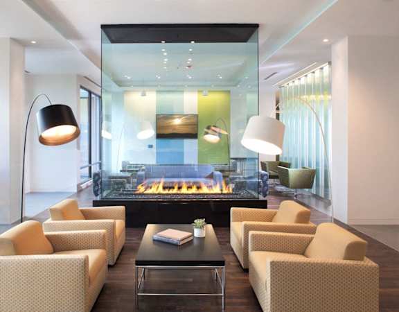 A modern living room with a fireplace and a glass table.