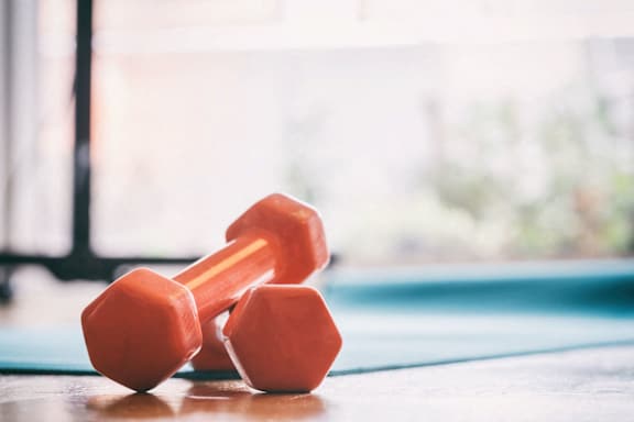 a pair of dumbbells on a table next to a pool