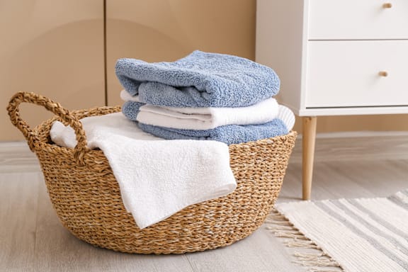 A basket filled with blue and white towels.
