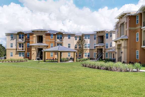 an apartment building with a green lawn in front of it