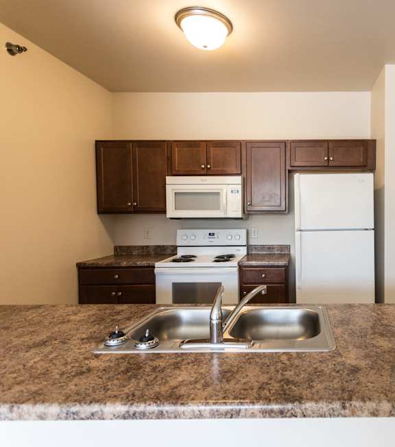 A kitchen with a granite countertop and stainless steel sink.