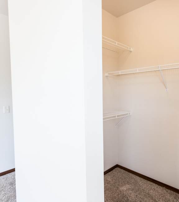 A room with a white wall and a white shelf.