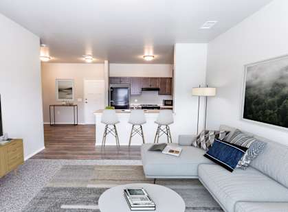 A living room with a grey couch and a white coffee table.