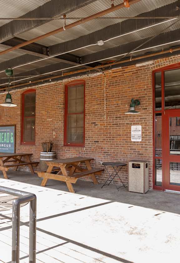 A brick building with a red door and a sign that says "BREAKFAST".