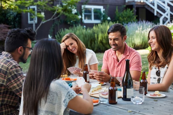 a group of people eating and drinking at a picnic table