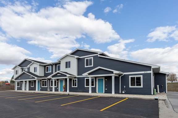 A large building with a parking lot in front.