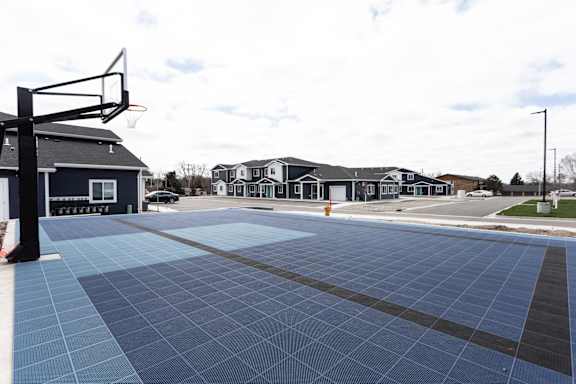 A basketball court with a blue and black tiled surface.