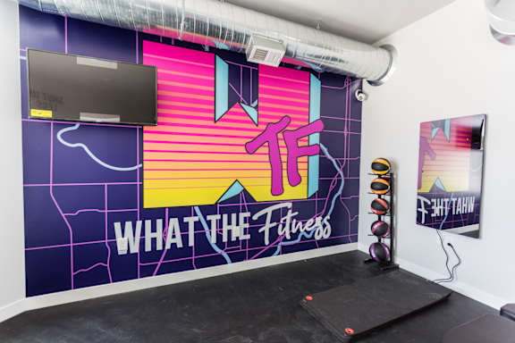 A wall with a map and the words "What the Fitness" written on it.