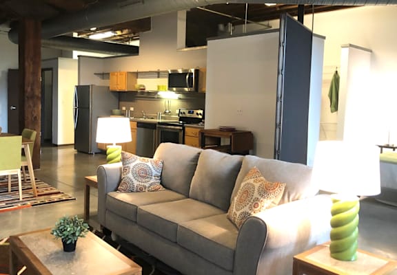 a living room with a couch and a kitchen in the background