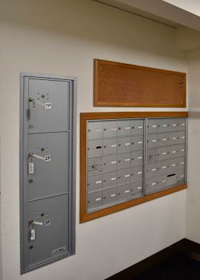 A grey metal locker with a keypad and a brown board above it.