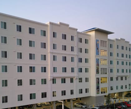 A large white building with a parking lot in front.