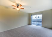 Thumbnail 11 of 22 - A room with a ceiling fan and carpeted floor.