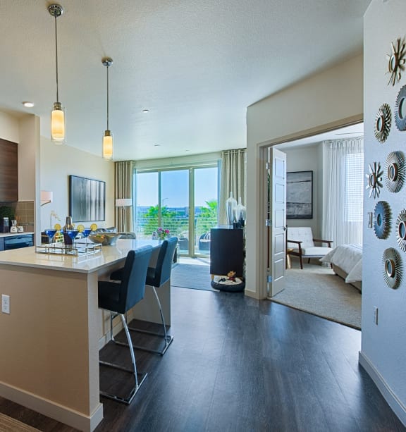a kitchen with a large island with three stools at The View at Cascade Apartments, Scottsdale, Arizona