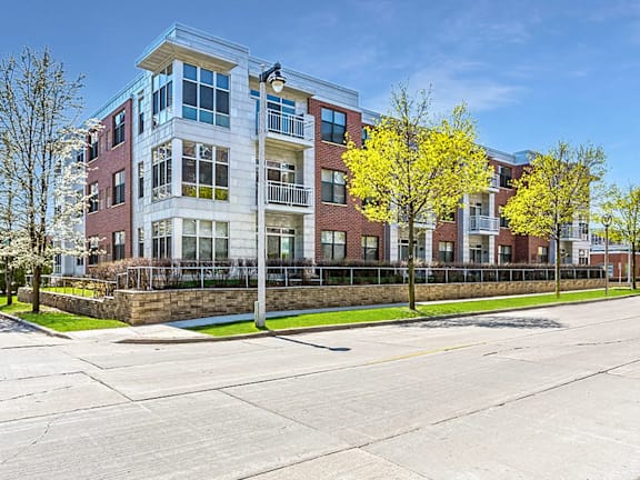 A modern apartment building with a parking lot in front.