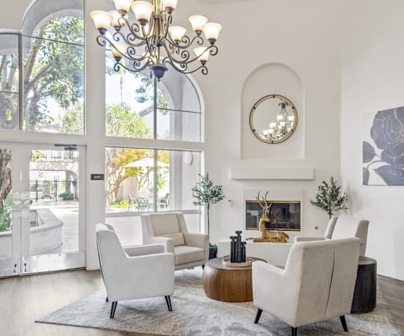 a living room with white furniture and large windows