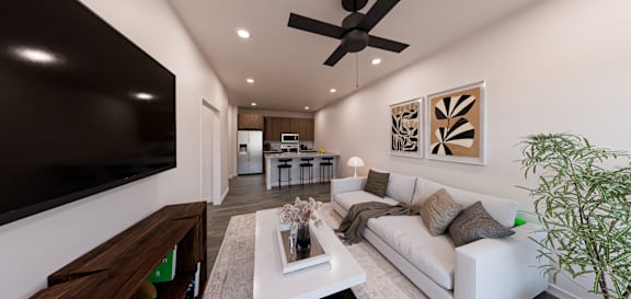 A modern living room with a white couch and a large flat screen TV mounted on the wall at Verity Luxury Apartment Homes Apartments, Vero Beach, FL 32960