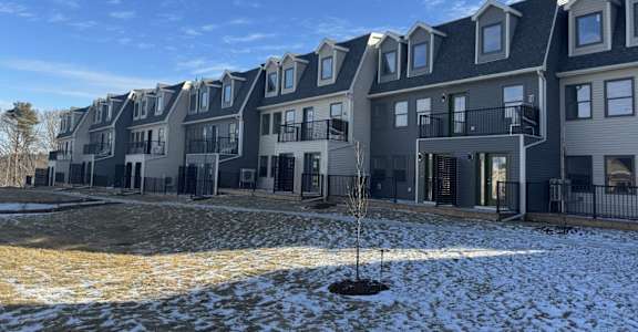 a snow covered yard in front of an apartment building