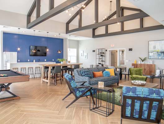 a clubhouse with a pool table and a living room with a dining area at Westown at Wilson, Michigan, 49534