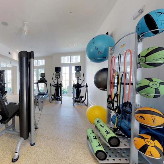 A gym with a variety of equipment including weights and exercise balls.