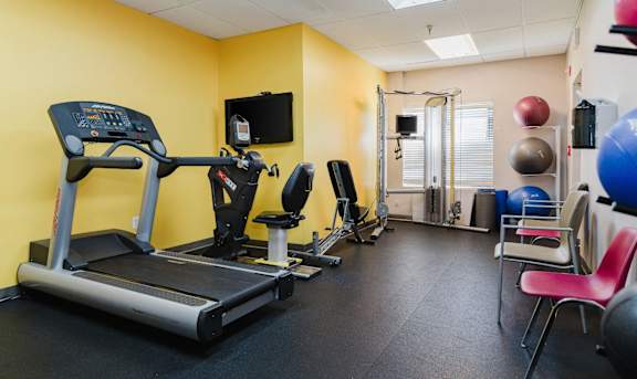 A gym room with a treadmill, exercise balls, and weights at Branchwood Towers, Clinton, MD, 20735