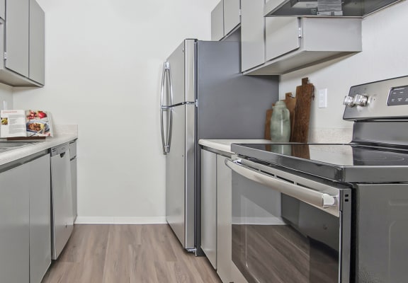 a kitchen with gray cabinets and stainless steel appliances  at University Glen, Washington, 98466
