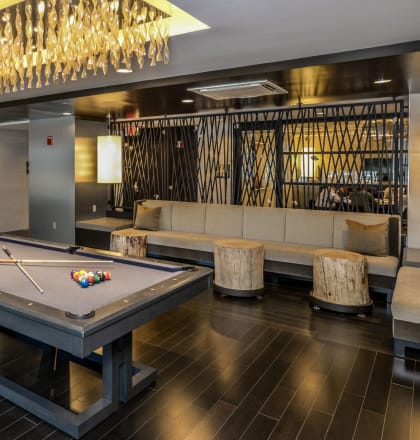 a pool table in a room with a bar and a chandelier