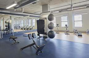 A gym with a variety of equipment including weights and exercise balls.