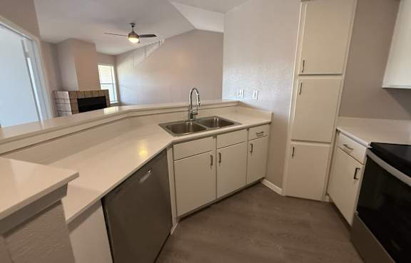 A kitchen with white cabinets and a black dishwasher. at Brook Meadow Village Apartments , Austin, TX, 78758