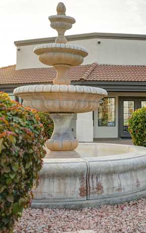 A house with a fountain in front of it.