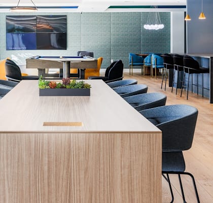 a communal table and chairs in an open office space