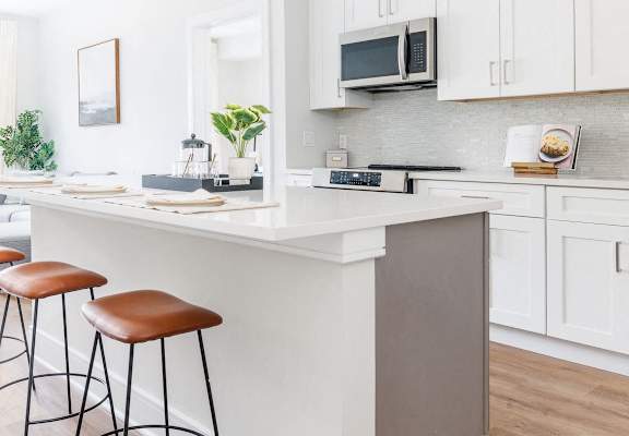 a kitchen with a counter and three stools