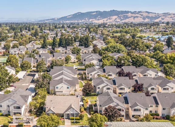 A bird's eye view of a residential neighborhood with houses and parked cars.